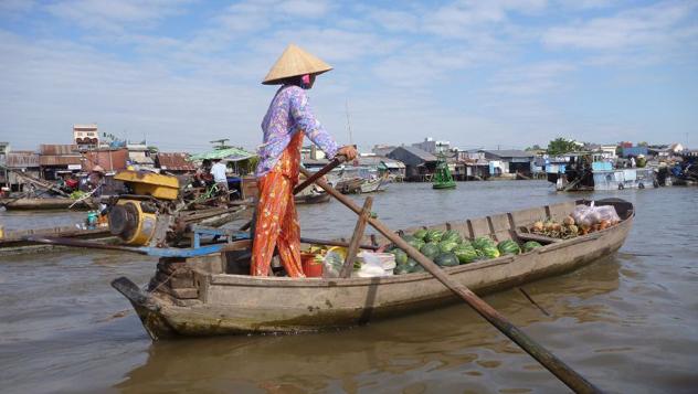 comerciante en barca con sus productos, navegando el río MeKong
